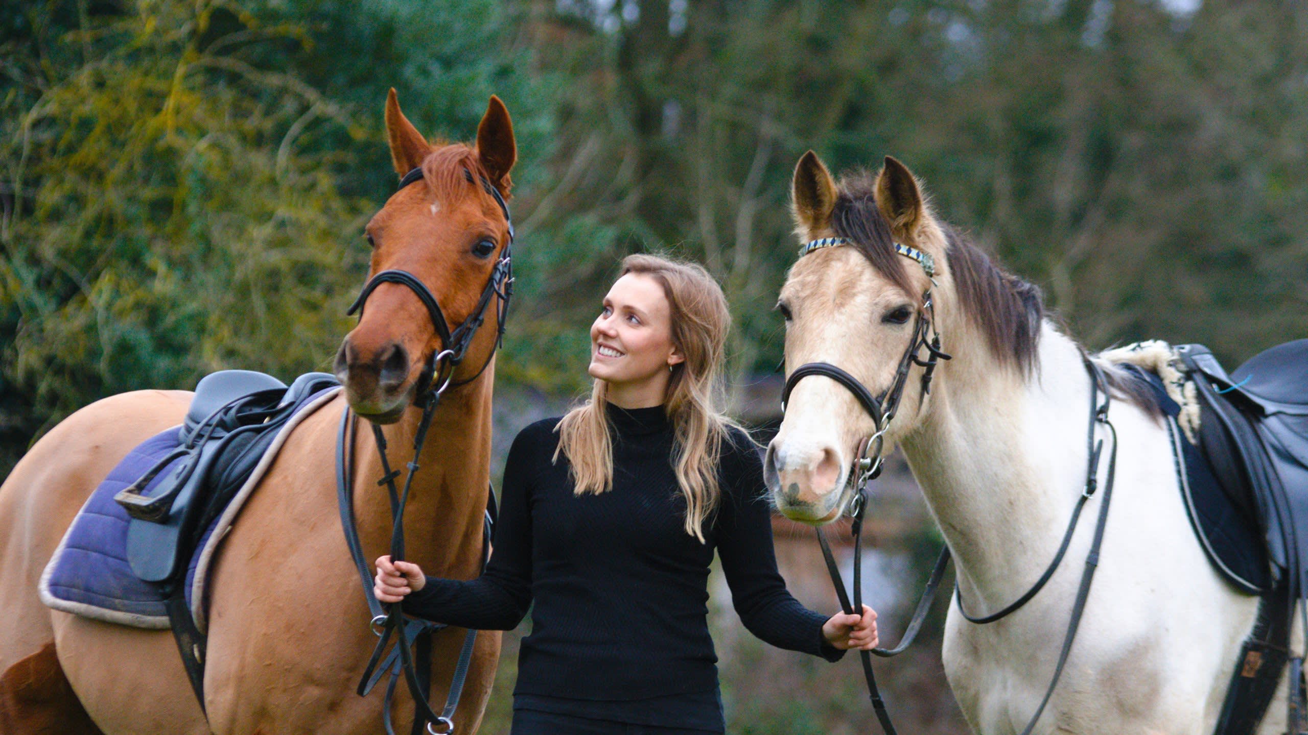 Caroline holding the reins of two horses